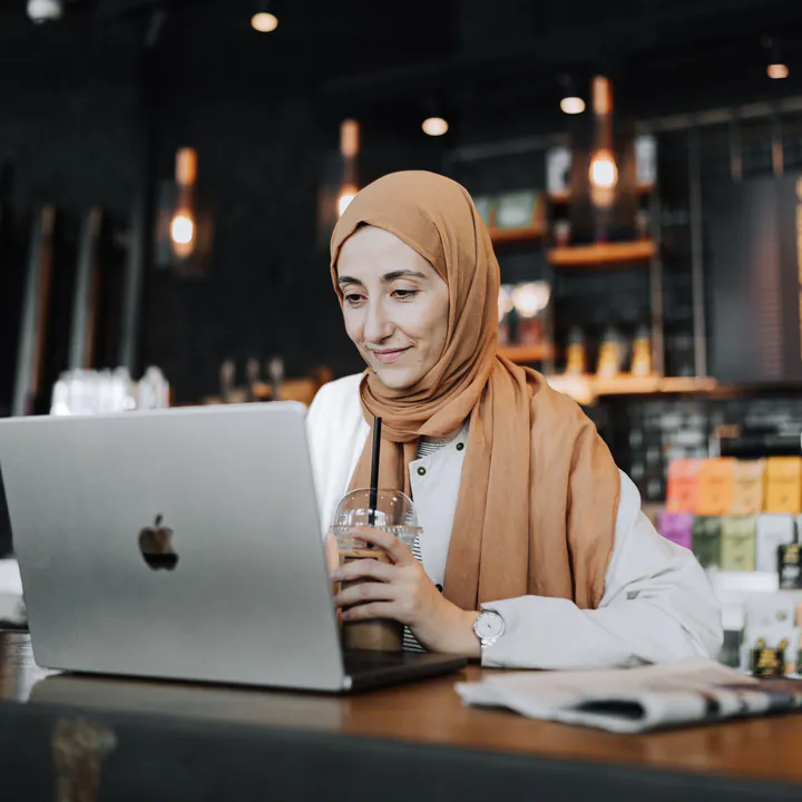 A woman running her own business from a laptop in a café